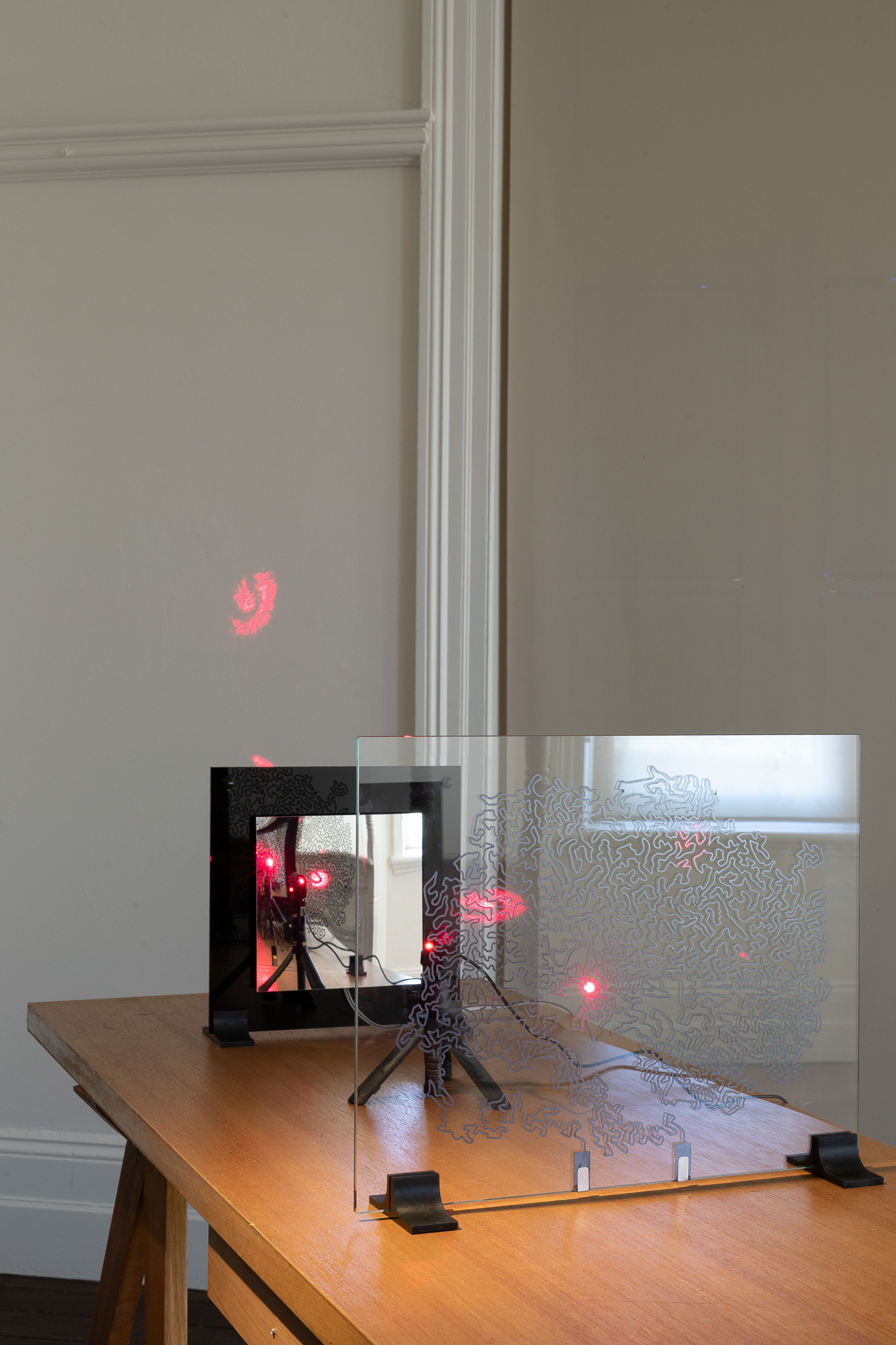 <p>Joyce Hinterding, Mirror line crackle, 2026. Sound recordings, tactile speakers, acrylic mirror, lasers and graphite drawing on glass. Photo Jessica Maurer</p>